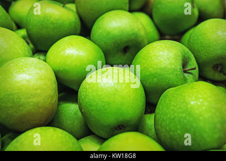 Reif ausgewählte Granny Smith Äpfel in Zeilen auf ein Lebensmittelgeschäft zum Verkauf. Grüner Hintergrund von Granny Smith Äpfel. Horizontale. Ansicht von oben. Stockfoto
