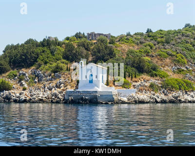 Eine kleine weiße Kirche steht auf Felsen ot am Wasser auf der Insel Ithaka Stockfoto