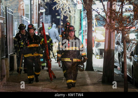 New York, USA. 29 Dez, 2017. Feuerwehrmänner Spaziergang auf der Website von einem Wohnungsbrand in Bronx, New York, USA, Dez. 29, 2017. Mindestens 12 Menschen wurden getötet, darunter ein Kind, bei einem Feuer Donnerstag Abend im Norden von New York City brach, lokale Behörden, sagte. Credit: Wang Ying/Xinhua/Alamy leben Nachrichten Stockfoto