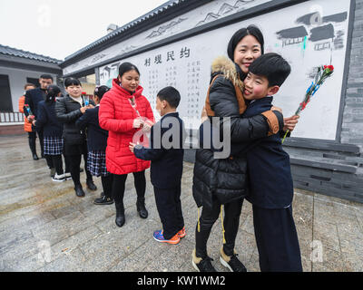 Changxing, der chinesischen Provinz Zhejiang. 29 Dez, 2017. Studenten präsentieren Blumen an die Eltern während eines 10-jährigen Zeremonie an einer Grundschule in Changxing County, der ostchinesischen Provinz Zhejiang, Dez. 29, 2017. Verschiedene Aktivitäten wurden an den Primär- und den mittleren Schulen in der Grafschaft statt das neue Jahr zu begrüßen. Credit: Xu Yu/Xinhua/Alamy leben Nachrichten Stockfoto