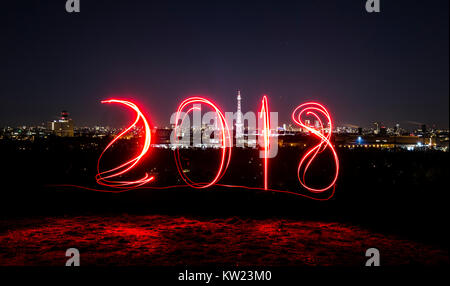 Berlin, Deutschland. 29 Dez, 2017. Ein Mann Spuren aus '2018' unter Verwendung eines Schweißbrenners an Drachenberg Hill in Berlin, Deutschland, 29. Dezember 2017. Credit: Paul Zinken/dpa/Alamy leben Nachrichten Stockfoto