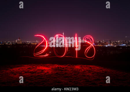 Berlin, Deutschland. 29 Dez, 2017. Ein Mann Spuren aus '2018' unter Verwendung eines Schweißbrenners an Drachenberg Hill in Berlin, Deutschland, 29. Dezember 2017. Credit: Paul Zinken/dpa/Alamy leben Nachrichten Stockfoto