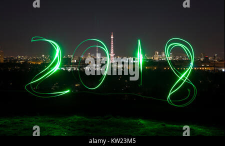 Berlin, Deutschland. 29 Dez, 2017. Ein Mann Spuren aus '2018' unter Verwendung eines Schweißbrenners an Drachenberg Hill in Berlin, Deutschland, 29. Dezember 2017. Credit: Paul Zinken/dpa/Alamy leben Nachrichten Stockfoto