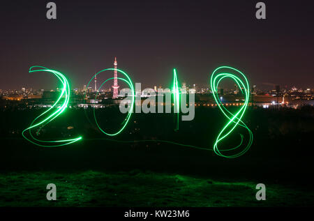 Berlin, Deutschland. 29 Dez, 2017. Ein Mann Spuren aus '2018' unter Verwendung eines Schweißbrenners an Drachenberg Hill in Berlin, Deutschland, 29. Dezember 2017. Credit: Paul Zinken/dpa/Alamy leben Nachrichten Stockfoto