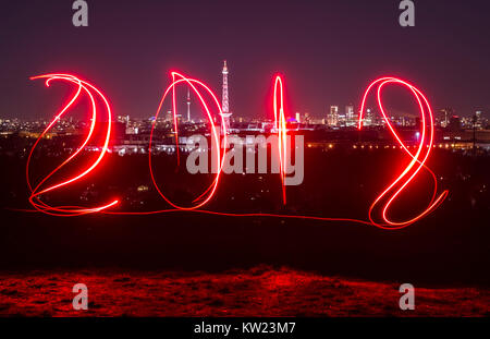 Berlin, Deutschland. 29 Dez, 2017. Ein Mann Spuren aus '2018' unter Verwendung eines Schweißbrenners an Drachenberg Hill in Berlin, Deutschland, 29. Dezember 2017. Credit: Paul Zinken/dpa/Alamy leben Nachrichten Stockfoto