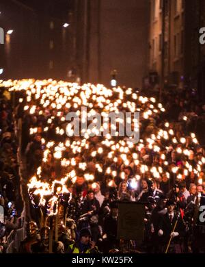 Edinburgh, Großbritannien. 30 Dez, 2017. Edinburgh's Hogmanay Feiern beginnen mit dem traditionellen torchlit Prozession. In diesem Jahr die Route endet außerhalb des Schottischen Parlaments in Holyrood, wo ein Wort von den jungen Menschen in Schottland gewählt, dass macht Sie Stolz in dem Land zu leben, die von Tausenden von fackelträger offenbart wird. Im Bild: Fackelzug entlang der Canongate Credit: Rich Dyson/Alamy leben Nachrichten Stockfoto