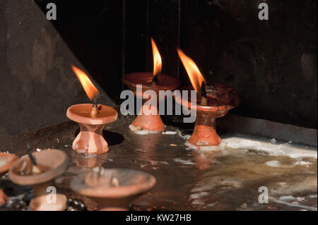 Buddhistischen Ton Gebet Kerzen in die Mauer der Armut. Stockfoto