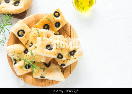 Traditionelle italienische Focaccia mit schwarzen Oliven und Rosmarin - hausgemachte Fladenbrot focaccia auf weissem, Ansicht von oben und kopieren Raum Stockfoto