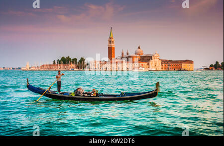 Schöne Aussicht auf traditionelle Gondel am Canal Grande mit der Kirche San Giorgio Maggiore im Hintergrund bei Sonnenuntergang, San Marco, Venedig, Italien Stockfoto