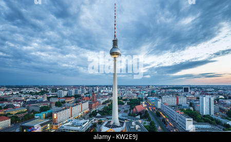 Luftaufnahme der Berliner Skyline mit berühmten Fernsehturm am Alexanderplatz und dramatische Wolkengebilde im Zwielicht während der blauen Stunde in der Abenddämmerung mit Retro-Vintage V Stockfoto