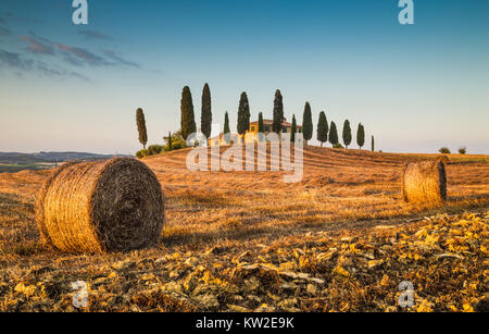 Wunderschöne Toskana Landschaft mit traditionellen Bauernhof Haus und Heuballen im goldenen Abendlicht, Val d ' Orcia, Italien Stockfoto