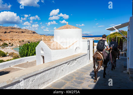 Jungen Reiten Esel auf dem Weg Akropolis von Lindos, die Griechisch-orthodoxe Kirche (Rhodos, Griechenland) Stockfoto