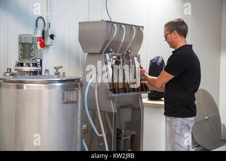 Abfüllung Brauerei Bier durch Abfüllung von Bier Flaschen mit Spachtel / Füller in der lokalen Brauerei Stockfoto