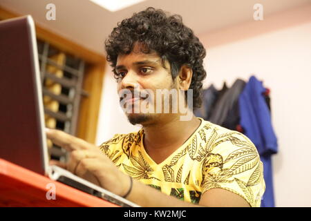 Chennai, Indien - 20. Mai 2016: Junger Mann mit Laptop und lächelnd in kreative Büro Stockfoto