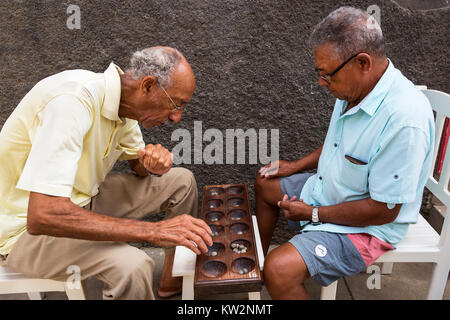 Lokale Männer spielen die traditionellen afrikanischen Brettspiel ouril, auch als mancala, oware, uril, ouri oder Ori bekannt, in den Straßen von Santa Maria, Afrika Stockfoto