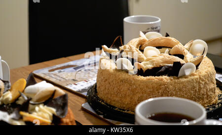 Kaffee Tassen Tassen mit zwei Dessert kuchen Torten auf hölzernen Tisch zu Hause. Stockfoto