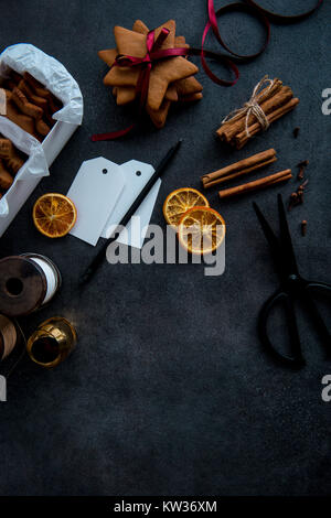 Geschenkpapier Weihnachten Lebkuchen Cookies. Saisonale Hintergrund Schuß von oben. Flach. Der dunkle Hintergrund. Stockfoto