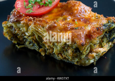 Nahaufnahme von Lachs Lasagne auf einer schwarzen Platte Stockfoto