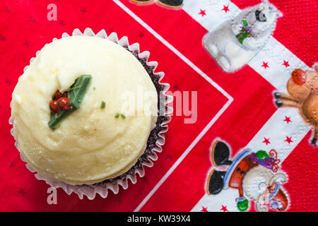 Christmas Pudding Red Velvet Muffin auf Weihnachten serviette Stockfoto