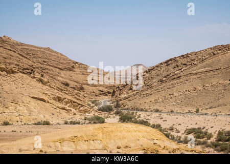 Die Straße zwischen den Hügeln in der Wüste Negev, die von den farbigen Sand (Israel) Stockfoto