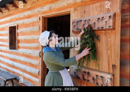 USA Virginia VA-kolonialen Yorktown Bauernhof an der Amerikanischen Revolution Museum bei Yorktown eine Geschichte interpreter außerhalb der Küche mit stechpalmen Kranz Stockfoto