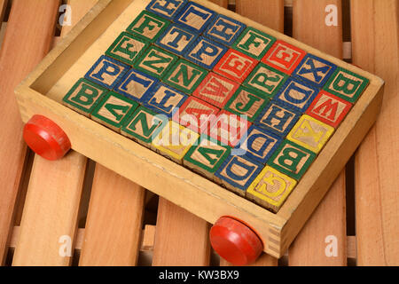 Kinder spielen Holz Wörter Bausteine im Warenkorb. Stockfoto