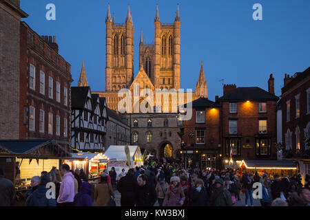 Der jährliche Weihnachtsmarkt in Bergauf Lincoln jedes Jahr. Der Blick auf die Kathedrale von Lincoln durch den Markt umgeben wie die Nacht fällt. Stockfoto