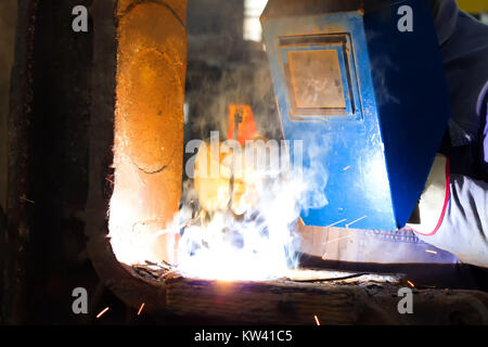 Schweißer mit Schutzmaske arbeitet auf Metall Schweißen Stockfoto