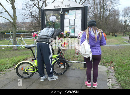 Die Menschen aufhören an Nachrichten und Blumen in Gedenken an Iuliana Tudos, die in Nord London Park in Finsbury Park ermordet gefunden wurde, um Links zu sehen, mehrere Hundert Meter von Ihrem Haus am Heiligabend. Stockfoto