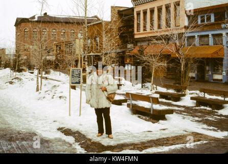 Frau trägt einen großen Fell Jacke steht im Aspen Mall in Aspen, Colorado, 1975. Stockfoto