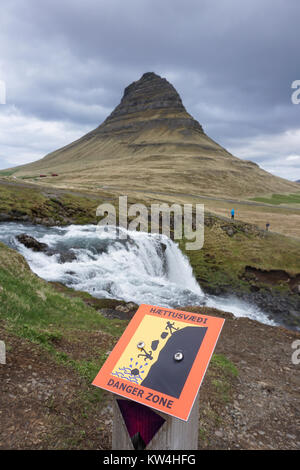 Warnschild in der Nähe von Kirkjufellsfoss Wasserfall auf der Halbinsel Snaefellsnes im Westen Islands. Kirkjufell Berg ist im Hintergrund. Stockfoto