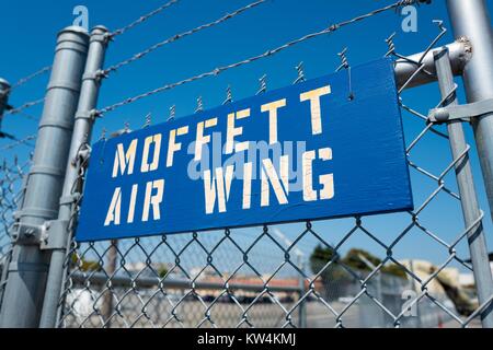 Blau und Weiß stenciled Zeichen für die Moffett Luft Flügel hängen an einem Stacheldrahtzaun auf Moffett Field, im sicheren Bereich des NASA Ames Research Center Campus im Silicon Valley Town in Palo Alto, Kalifornien, 25. August 2016. Stockfoto