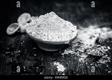 Raw Pulver von Henna, Lawsonia inermis in ein irdenes Gefäß mit Zitronen und Nelken. Stockfoto