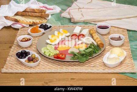 In der Nähe der traditionellen türkischen Frühstück serviert auf Porzellan Teller mit Käse, Salami, gekochtem Ei, Tomaten, Gurken und geröstetem Brot Stockfoto