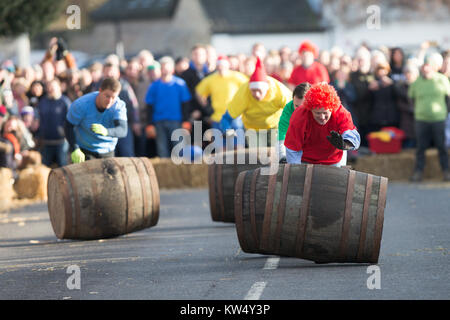 Bild zeigt Konkurrenten versuchen, ihren Lauf in den jährlichen Boxing Day Barrel Race im Dorf Grantchester in der Nähe von Cambridge zu steuern. (Dec 26) Teams aus den vier lokalen Pubs konkurrieren, in der Regel vier in einer Zeit der leeren Fässer bis die Straße so schnell wie möglich zurückzufahren, ohne zu verletzen die Massen der Zuschauer, die Gefahr für Leib und Leben während Schreien Ermutigung von hinter einer dünnen Wand von Strohballen. Stockfoto