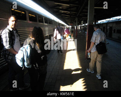Dieses Bild zeigt Passagiere, die in einen Zug einsteigen, eine häufige Szene im frühen 20. Jahrhundert. Das Foto spiegelt die Reisekultur der Zeit wider und zeigt den Prozess der Zugfahrt und ihre Rolle im täglichen Leben. Stockfoto