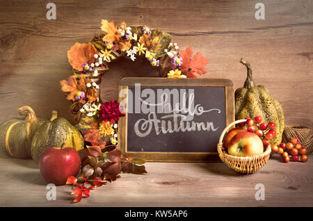 Herbst Arrangement mit Lorbeerkranz und Schriftzug "Hallo Herbst' auf einer Kreidetafel. Dieses Bild wird gestrafft. Stockfoto
