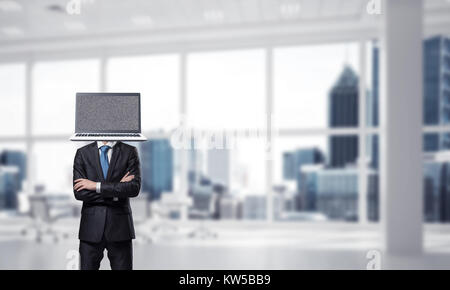 Zugeschnittenes Bild der Geschäftsmann in Anzug mit Laptop anstelle von Kopf, Armen, während im Bürogebäude gekreuzt. Stockfoto