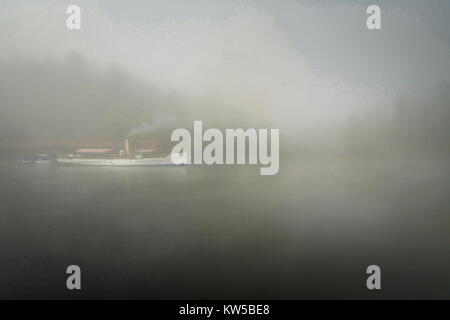 Das dampfschiff Sir Walter Scott macht bereit in der atmosphärischen am frühen Morgen zu segeln zwischen den Inseln im Nebel am Loch Katrine, Perthshire, Schottland ummantelt Stockfoto