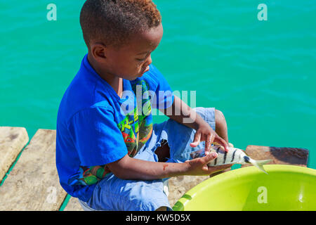 Jungen aus Santa Maria, Insel Sal, Salina, Kap Verde, Afrika ein Fisch, den er gerade gefangen hat. Stockfoto