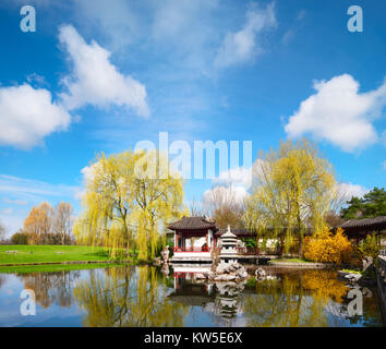 Stein-Pagode im Teich eines formalen chinesischen Gartens, Berlin, Deutschland. Konzentrieren Sie sich auf den steinernen Turm in der moddle Stockfoto