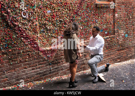 Mann schlägt die Ehe mit einer Frau vor der Gummi an der Wand in den Pike Place Market, Seattle, Washington Stockfoto