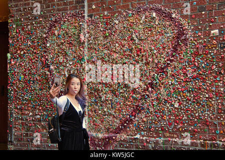 Asiatische Frau unter selfie vor dem Kaugummi Wand, Seattle, Washington, USA Stockfoto