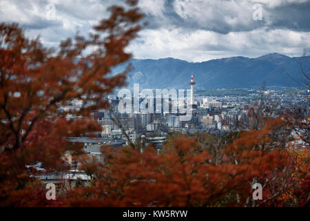 Kyoto Tower unter dramatischen Himmel in Antenne Stadt Landschaft durch rote Herbst Baum Blätter. Kyoto, Kyoto, Japan 2017. Stockfoto