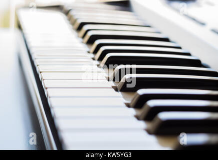 Eine elektronische Tastatur wird in einem hellen Raum neben einem offenen Fenster. Dies ist ein helles Bild mit dem Fokus auf der Tastatur ivory Keys. Stockfoto