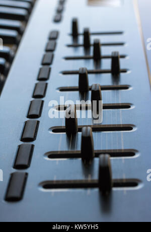 Eine elektronische Tastatur wird in einem hellen Raum. Es verfügt über einen 8-Kanal control board in mit Fader und Regler gebaut. Stockfoto