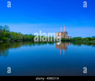 Ein Bild von einem Kraftwerk neben einem Fluss. Das ist ein Bild für die Menschheit die Natur auswirken. Dies war im Hochsommer vom Bug eines Bootes. Stockfoto