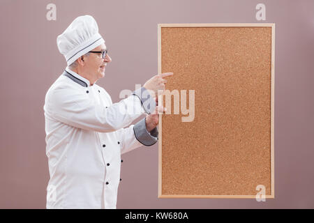 Portrait von Chefkoch in Uniform zeigen, was ist" im Menü Stockfoto