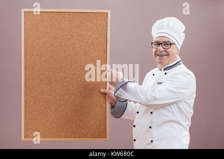 Portrait von Chefkoch in Uniform zeigen, was ist" im Menü Stockfoto