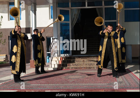 Taschkent Usbekistan - 9. Dezember 2011: Musiker Männer in traditionelle Kaftane spielen Der karnay am Eingang Stockfoto